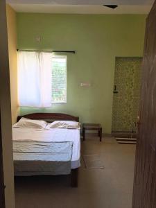 a bedroom with a bed and a window at The Circle in Auroville