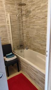 y baño con bañera y silla junto a la bañera. en Fougères 77 m2, 2 chambres, garage , Balcon, en Fougères