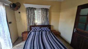 Schlafzimmer mit einem Bett mit blauem Kleid in der Unterkunft Logement Petit Studio Salazamay Tamatave Madagascar in Toamasina
