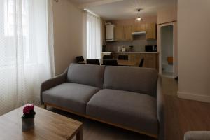 un salon avec un canapé et une table dans l'établissement L'Hibiscus Rouge, à Brest