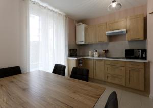 une cuisine avec une grande table et des chaises en bois dans l'établissement L'Hibiscus Rouge, à Brest