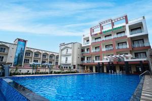 a large swimming pool in front of a building at Gogol Beach Resort in Mandarmoni