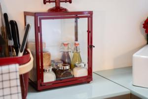 a small glass shelf with bottles on a counter at 9b-The Tiny House in Sežana