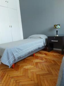 1 dormitorio con 1 cama y suelo de madera en Caballito Apartment en Buenos Aires