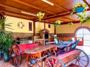 une terrasse avec une table en bois et une charrette en bois dans l'établissement Exquisite rural house with garden, pool and sea views, à Arico Viejo