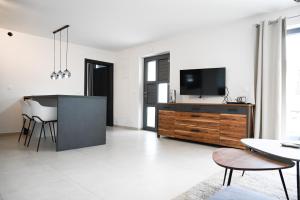 a living room with a television and a table at Sunshinewilla com - amazing sea view - private pool - 4 bedrooms - 3 bathrooms - workout in Kaštelir