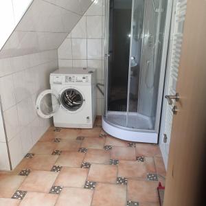 a small bathroom with a washing machine and a shower at Pension Haus am Malesfelsen in Albstadt