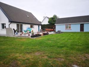 a white house with a yard with a yard at Tranquil Country Escape West Coast Adventure Awaits in Galway