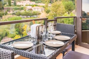 une table en verre avec des assiettes et des verres à vin sur un balcon dans l'établissement Monaco Border, sea view, Parking, à Beausoleil