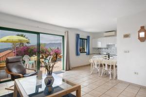 Los BarrosにあるLa Villa La Palma- 2 dormitorios Bのテーブルと椅子、キッチンのあるリビングルーム