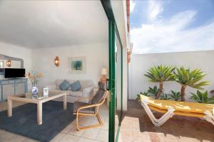 sala de estar con sofá, mesa y sillas en La Villa La Palma- 2 dormitorios B en Los Barros