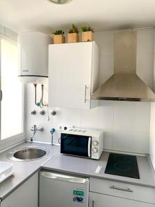 a small kitchen with a sink and a microwave at Alcalá zona Centro in Alcalá la Real