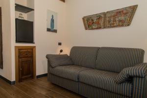 uma sala de estar com um sofá e uma televisão de ecrã plano em L' Amandola em Levanto