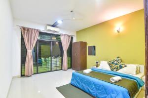 1 dormitorio con 1 cama azul y paredes amarillas en Villa le Nora, en Lonavala