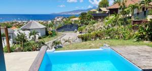 une maison avec une piscine et une vue sur l'océan dans l'établissement Appartement T3 -Villa Les Bougainvilliers, à Les Trois-Îlets
