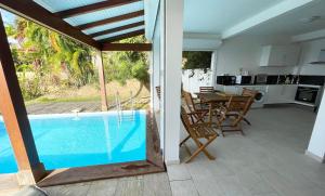 une maison avec une piscine, une table et des chaises dans l'établissement Appartement T3 -Villa Les Bougainvilliers, à Les Trois-Îlets