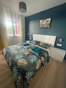 een slaapkamer met een bed met een tropische sprei bij L8 - Villiers-le-Bel proche ROISSY & PARIS in Villiers-le-Bel