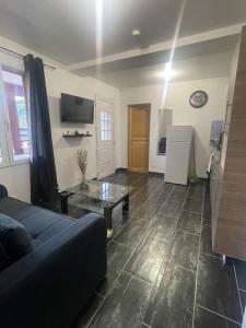 ein Wohnzimmer mit Sofa und Tisch in der Unterkunft L8 - Villiers-le-Bel proche Aéroport ROISSY CHARLES DE GAULLES & PARIS in Villiers-le-Bel + 19 Fotos