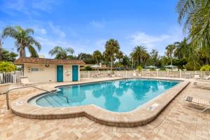 une grande piscine entourée de chaises dans l'établissement Siesta Beach Condo Rental with direct beach and pool access, à Siesta Key