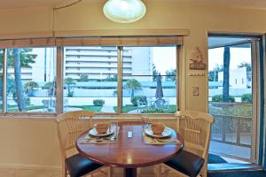 - une salle à manger avec une table et des chaises en bois dans l'établissement Siesta Beach Condo Rental with direct beach and pool access, à Siesta Key