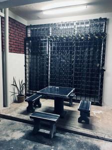 a ping pong table and benches in front of a wall at Daliya Homestay Ulu Tiram JB in Ulu Tiram