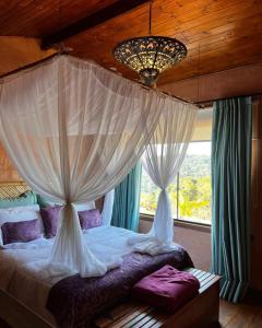a bedroom with a canopy bed with curtains and a window at Espaço Vento Solar in São Roque