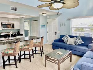 a living room with a blue couch and a table at Two story condo with ocean on one side and bay on other only steps away in Bradenton Beach