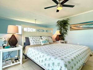 a bedroom with a bed and a ceiling fan at Two story condo with ocean on one side and bay on other only steps away in Bradenton Beach