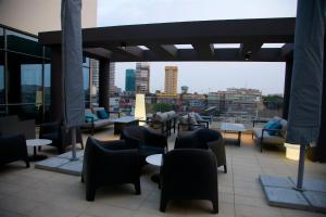 a balcony with chairs and tables and a view of a city at Hotel Continental Horizonte in Luanda