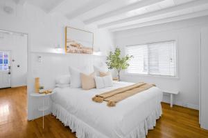 a large white bedroom with a large white bed at Newport Beach Cottage B in Newport Beach