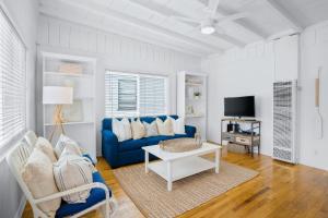 a living room with a blue couch and a tv at Newport Beach Cottage B in Newport Beach