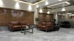 a lobby with two couches and a table at Hotel Sai Miracle in Shirdi