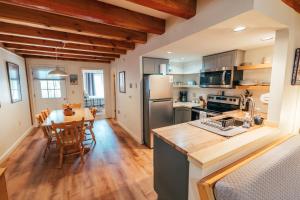 a kitchen and dining room with a dining table and a kitchen with at Newly Renovated & Furnished Condo, Only 3 min to Sunday River! in Bethel