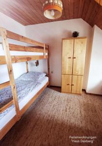 - une chambre avec 2 lits superposés et une armoire dans l'établissement Haus-Daxberg-idyllisch-gelegen-im-Bayerischen-Wald, à Eppenschlag