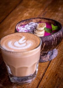 uma chávena de café e uma tigela de comida numa mesa em Mango Lodge em Selong Blanak