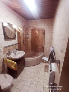 a bathroom with a tub shower and a sink at Haus-Daxberg-idyllisch-gelegen-im-Bayerischen-Wald-Ferienwohnung-mit-Zimmer-Kueche-Bad in Eppenschlag