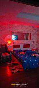 1 dormitorio con cama, sofá e iluminación roja en Lake View Mall en Bacău