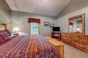 1 dormitorio con cama, tocador y espejo en Cozy Cub Cabin en Gatlinburg