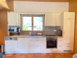 eine Küche mit weißen Schränken und einem Fenster in der Unterkunft Appartement Les Gets, 3 pièces, 6 personnes - FR-1-623-343 in Les Gets