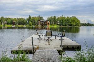 a dock with chairs and a house on a lake at Sand Lake View House in Anchorage