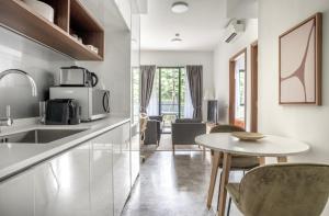 a kitchen with a sink and a table with chairs at Spectacular 2BR Apartment in Singapore in Singapore