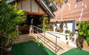 une maison avec des escaliers et des plantes en pot dans l'établissement GP House Phuket Patong Beach, à Patong Beach