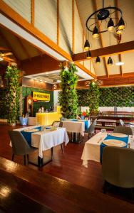 un restaurant avec des tables, des chaises et des plantes dans l'établissement GP House Phuket Patong Beach, à Patong Beach