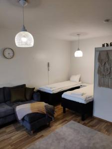 uma sala de estar com duas camas e um sofá em Hilla Apartments em Rovaniemi