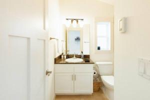 a white bathroom with a sink and a toilet at Modern 3BR in the Heart of Ballard in Seattle