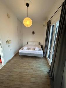 um quarto com uma cama e uma grande janela em Cozy Apartment in City Center. em Atenas