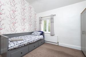 a bedroom with a bed and a window at Wakefield Canal Cottage - Parking, Self Check-in, Fast WiFi, Large Garden, Canal Side Views - Contractors, Families, Long Stays in Wakefield