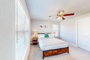a bedroom with a bed and a ceiling fan at Life is Good on 18th Street in Bentonville