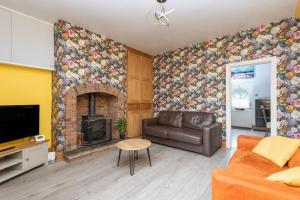 a living room with a couch and a fireplace at Wakefield Canal Cottage - Parking, Self Check-in, Fast WiFi, Large Garden, Canal Side Views - Contractors, Families, Long Stays in Wakefield
