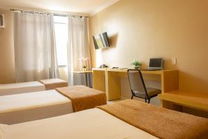 um quarto com 2 camas e uma secretária com um computador portátil em Hotel Diplomat em Brasília